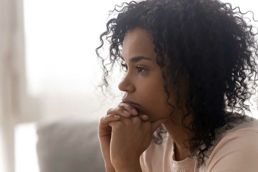 woman with curly hair considers the first sign of addiction