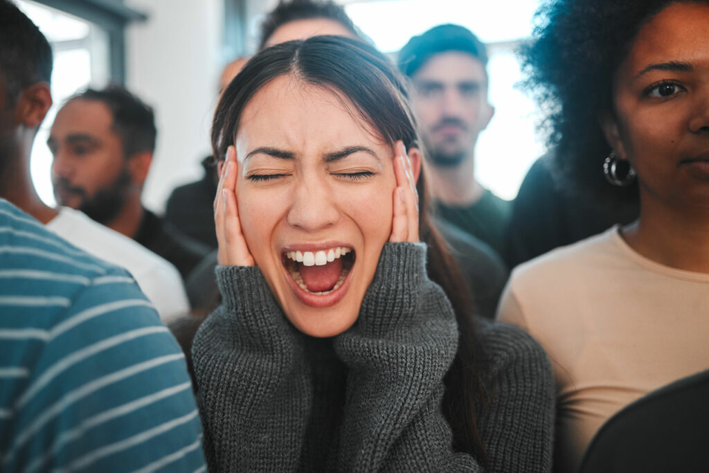 woman puts hands over ears while yelling about types of anxiety and panic disorders