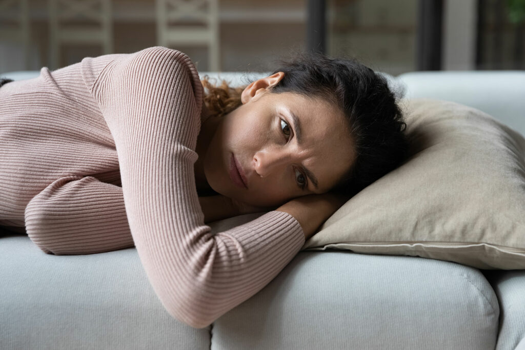 woman laying in bed wonders "am i sad or depressed"