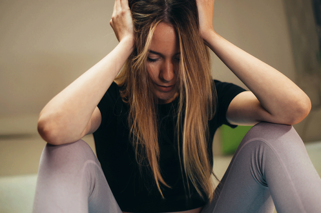 woman with head in hands considers cyclothymic disorder vs bipolar disorder