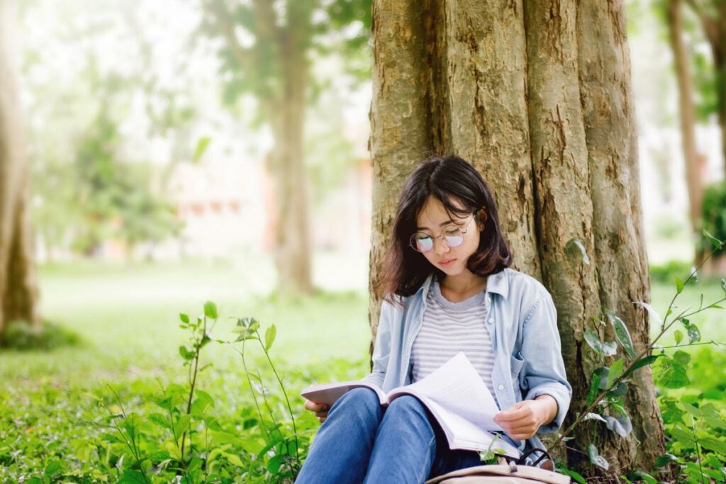 a person journals outside against a tree while healing from religious ocd thoughts