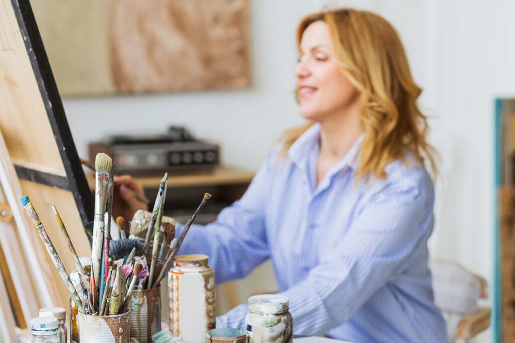 woman painting and experiencing the benefits of art therapy