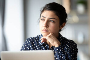 woman in a depression treatment program looks away from laptop