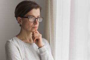 woman looks out of a window and considers types of mood disorders