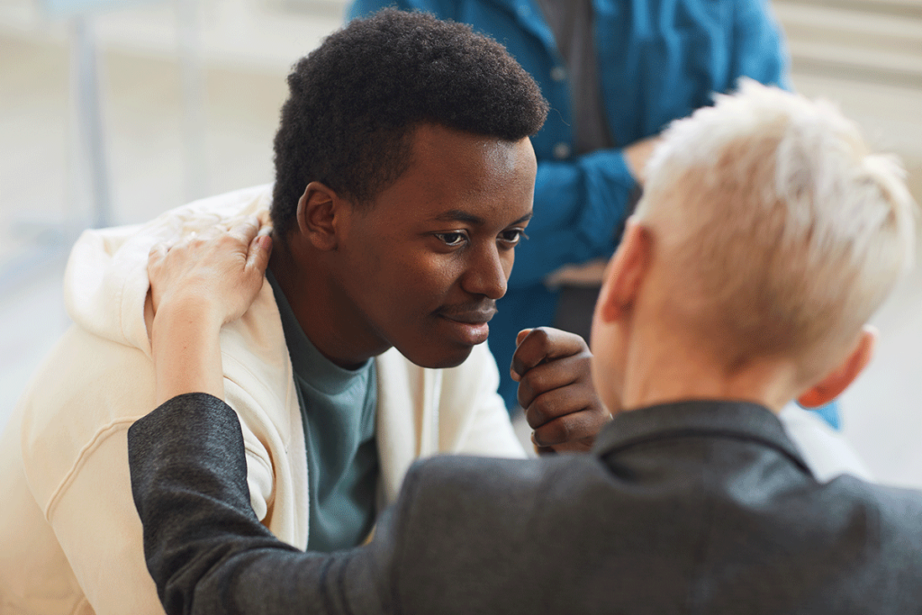 a person comforts another teen during teen bipolar disorder treatment