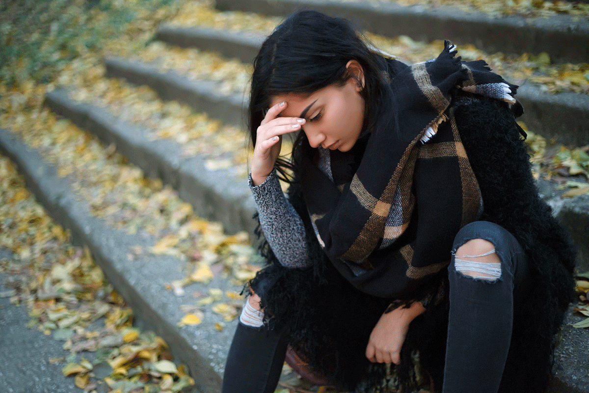 girl sitting outdoors wonders how trauma is treated in teens