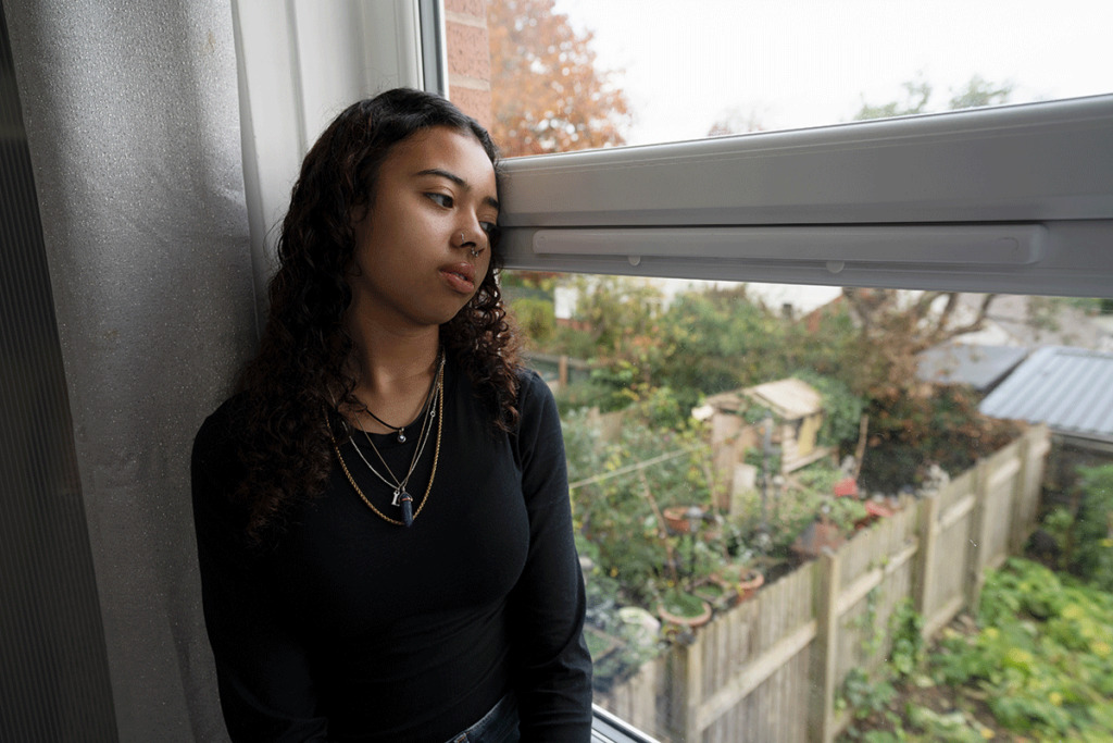 girl looking out window wonders if depression is a symptom of puberty
