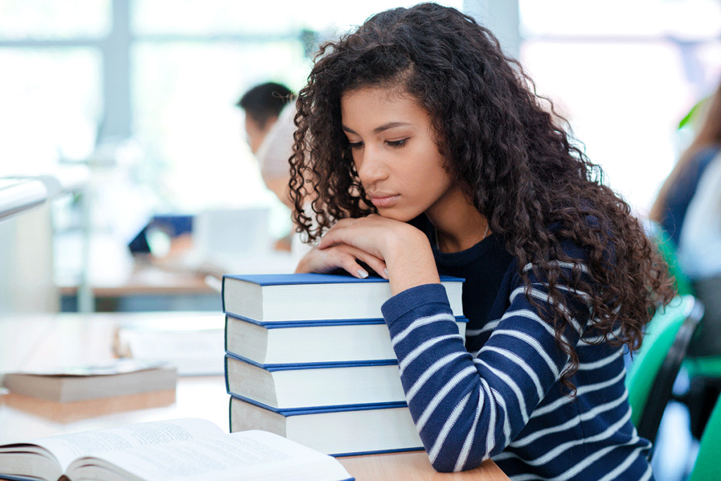 girl leaning on books considers the dangers of undiagnosed adhd